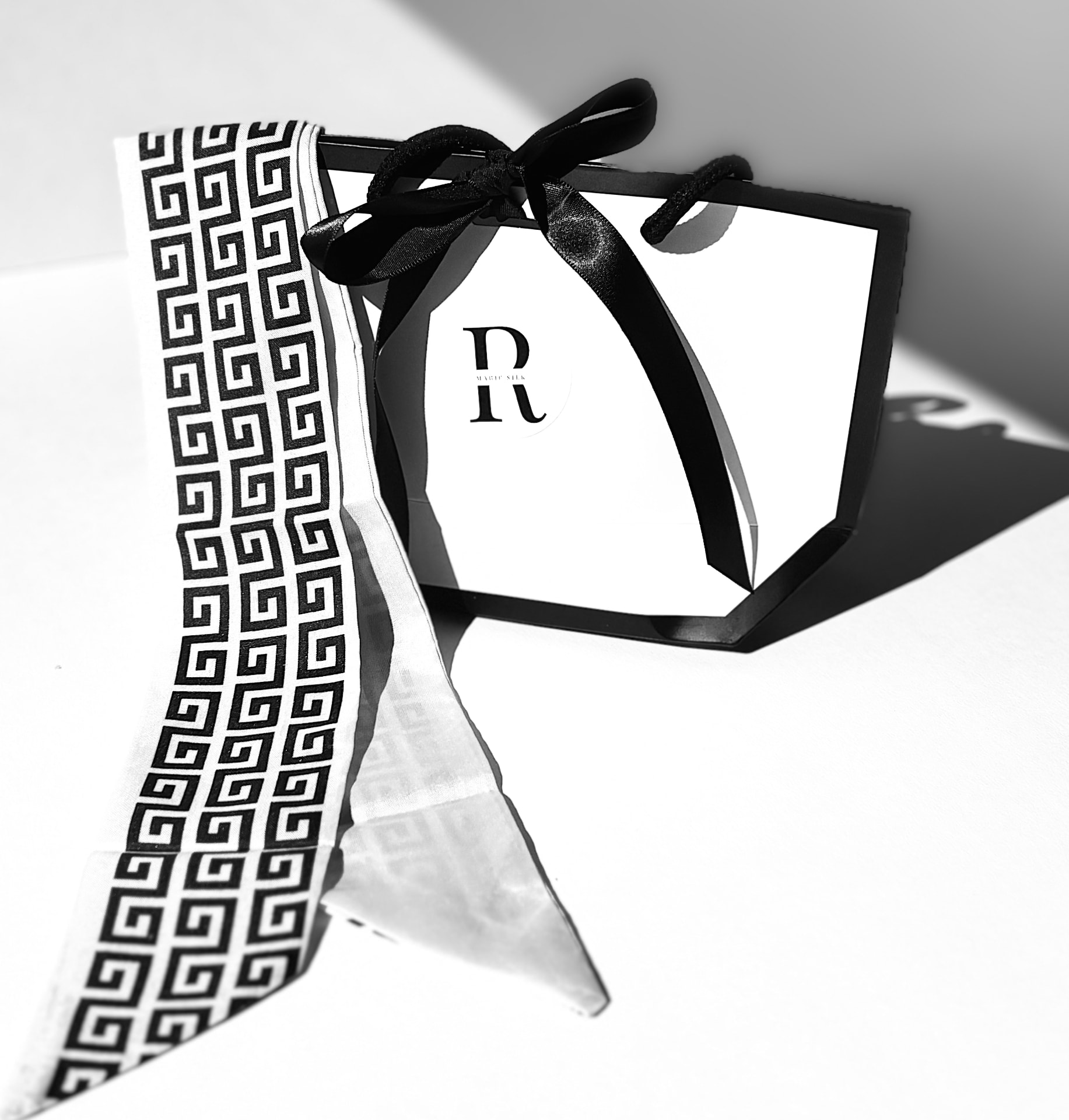 Bufanda de seda doblada junto a una bolsa de regalo RMagic Silk