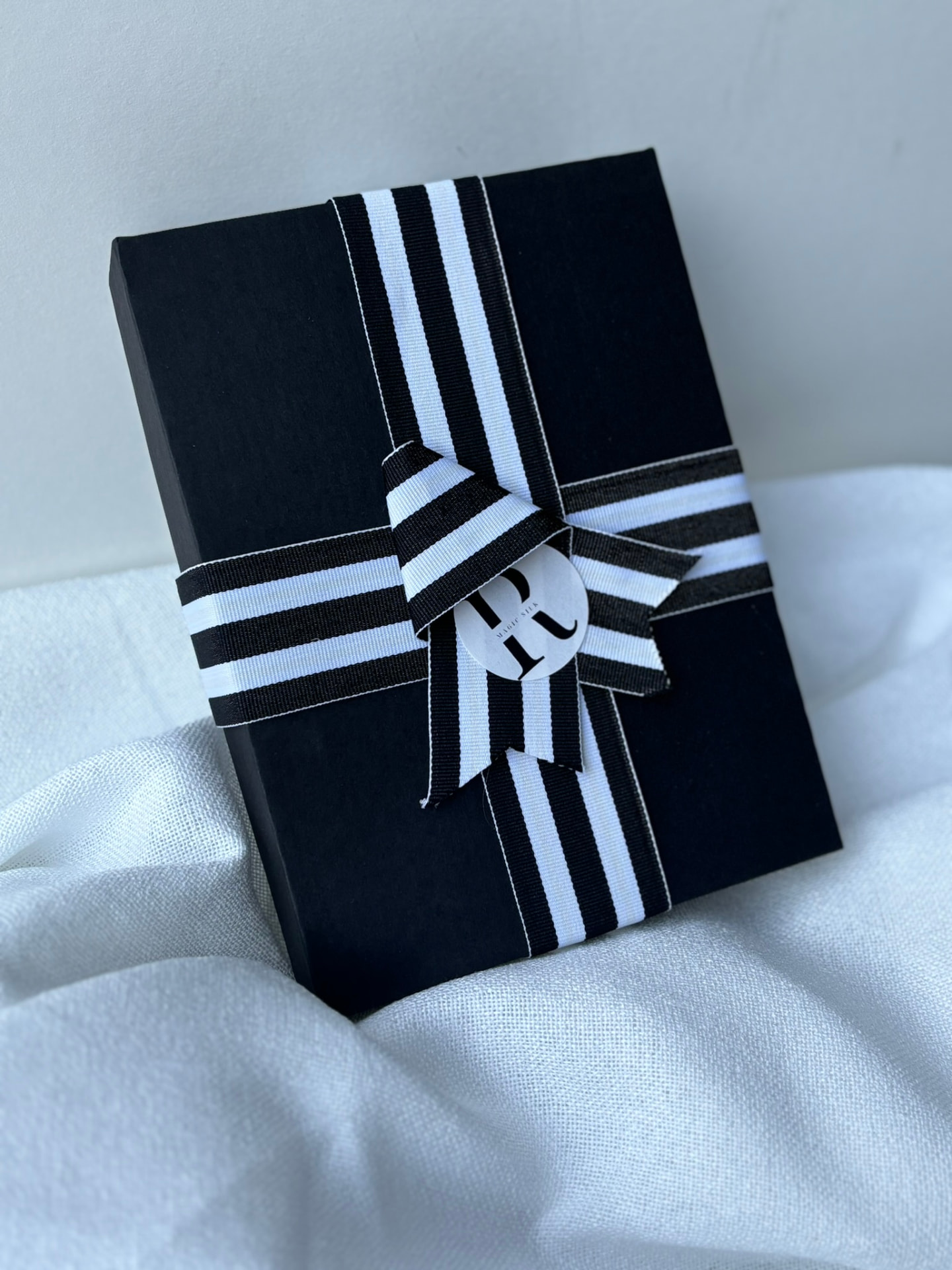 Detalle 2 de la caja signature RMAGIC SILK con cinta a rayas